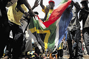 Protesters burn the South African flag in protest of the Human Rights Day commemorations being moved to Soweto from Sharpeville Picture: LEBOHANG MASHILOANE