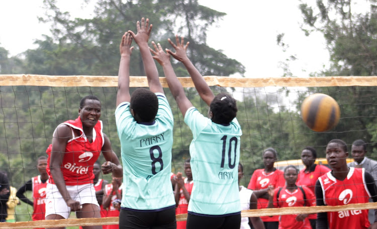 Juliana Namutira (red) Spikes the ball against the blocks of Parklands Arya's duo of Mary Naeku (L) and Shanice Nyanduko (R) during the Nairobi Region Games last week