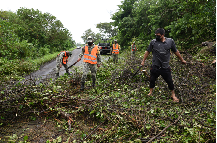 Military personnel remove fallen branches from a road after Hurricane Grace slammed into the coast with torrential rains, in Costa Esmeralda, near Tecolutla, Mexico on August 21 2021.