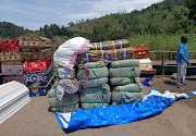 Workers arrange humanitarian relief and coffins for the Congolese civilians killed following rains that destroyed the remote, mountainous area and ripped through the riverside villages of Nyamukubi, Kalehe territory in South Kivu province of the Democratic Republic of Congo May 9, 2023.  