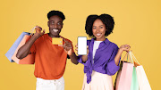 A vibrant couple enjoys a shopping spree, with the man in an  holding a credit card.