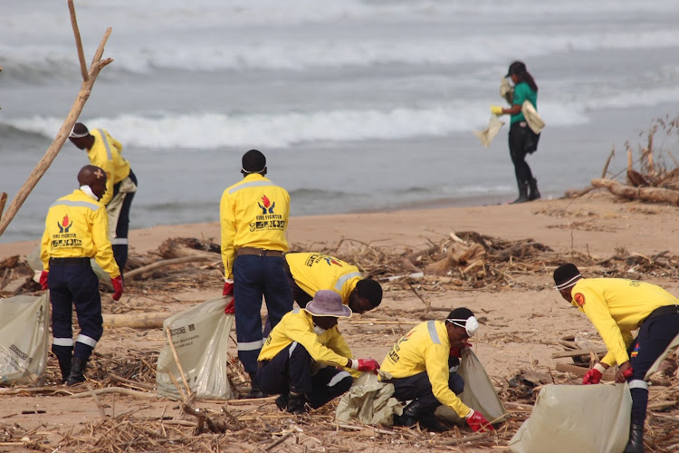 Members of Working on Fire picking up litter along the Durban shore following heavy flooding