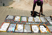 Mthokozisi Dyantyi, 31, sells the paintings of SA's Struggle heroes in Vilakazi Street, Orlando West, Soweto before the start of the ANC elective conference in Nasrec tomorrow.  /  SANDILE NDLOVU