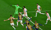 Croatia's Dominik Livakovic celebrates with teammates after saving a penalty shot taken by Brazil's Marquinhos and qualifying for the semi finals.