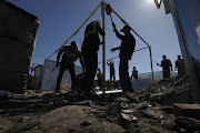 People from Joe Slovo informal settlement in Langa start rebuilding their homes after a large fire broke out on Saturday evening. 