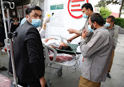 People transport an injured woman to a hospital after a blast in Kabul, Afghanistan May 8, 2021. 