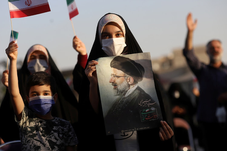 A supporter of Ebrahim Raisi displays his portrait during a celebratory rally for his presidential election victory in Tehran, Iran June 19, 2021.