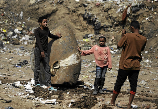 Youngsters from Matariya in Cairo pose with the head of an unearthed 8m statue that is said to depict Pharaoh Ramses II.