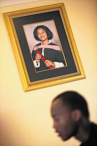 Kgositsile Sekwena, 18, sits under a portrait of his mother, Gloria. Both were queuing at the University of Johannesburg when she was crushed to death in a stampede. File photo.