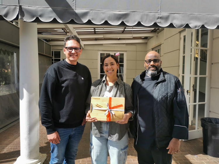 Winner Anna Coplan with Capsicum's Schalk Botes and chef John Mathi.