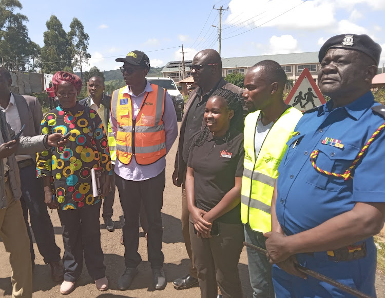 Bomet Central Deputy Subcounty Commissioner Victor Kisachi (centre) with NTSA regional coordinator Patrick Tilitei second (left) and Bomet County Traffic Enforcement Officer Ogolla (right) speak after a tree planting session at Bomet University College on May 15, 2024