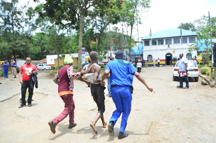 Two naked men who had climbed a tree preaching arrested by police at the Central Police Station in Nakuru on March 17, 2023.