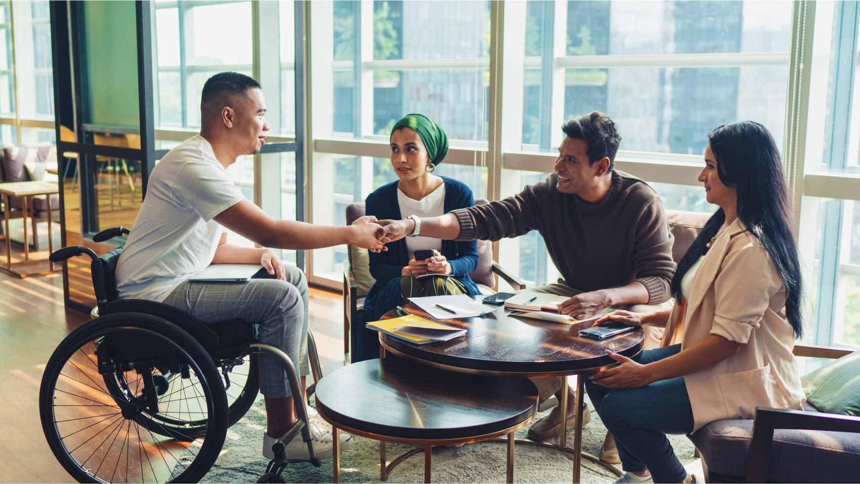 Un grupo inclusivo de personas conversan en un entorno de oficina