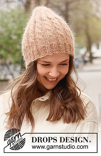 peach colored cable knit hat on model