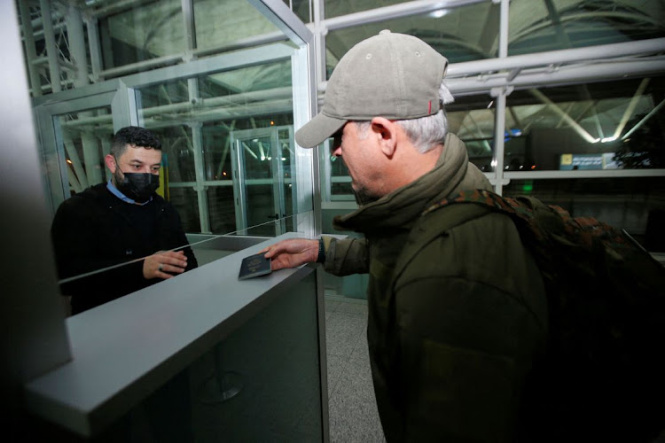 Emad Ballack, an Iraqi-American Kurd and businessman, who owns a restaurant in Kyiv, provides his passport at the airport check, as he plans to return to Ukraine to support Ukrainian soldiers against the Russian invasion, in Erbil, Iraq March 4 2022. Picture: REUTERS/AZAD LASHKARI