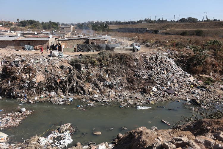 A truck dumps rubble onto the the heavily polluted banks of the Jukskei River near Alexandra in Johannesburg. File photo