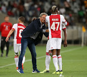 Ajax Cape Town players Tendai Ndoro and Yannick Zakri celebrate with head coach Muhsin Ertugral during the Absa Premiership match against Orlando Pirates at Cape Town Stadium on January 31, 2018 in Cape Town, South Africa.