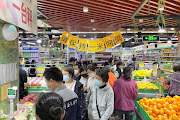 Customers wearing face masks line up to weigh their purchases at a supermarket following the coronavirus disease (Covid-19) outbreak in Beijing, China April 26, 2022. 