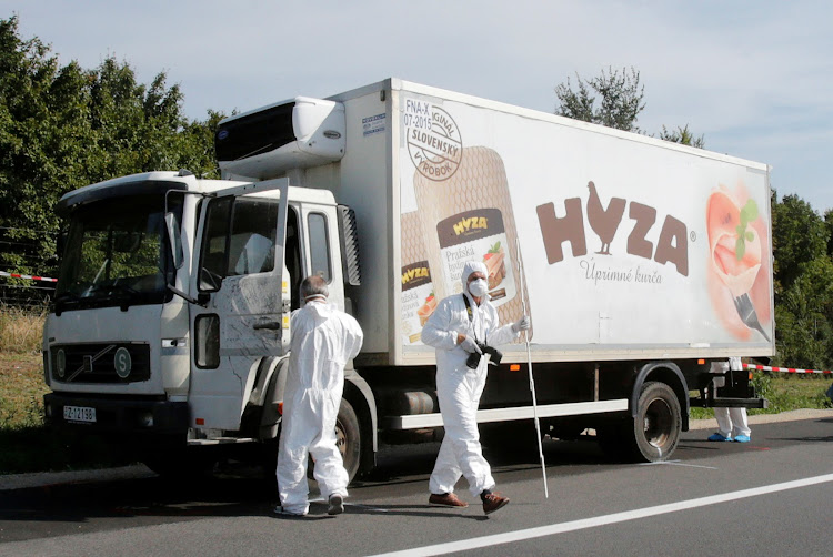 Forensic police officers inspect a parked truck in which up to 71 migrants were found dead on a motorway near Parndorf, Austria, on August 27 2015. Four human traffickers were jailed for life for their deaths in a final ruling in a Hungarian court on June 20 2019.