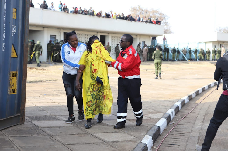 A woman is escorted to first aid area after being injured during a stampede at Kasarani Stadium, Nairobi on September 13, 2022