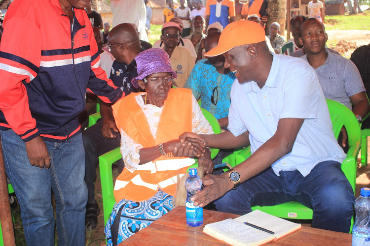 Kilifi governor hopeful Gideon Mung'aro shakes hand with one of the beneficiary of title deeds in Kadzinuni on Sunday