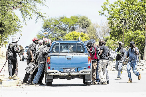 PIECE WORK: Men look for work with a potential employer outside the Builders Warehouse in North Riding, Johannesburg. The latest employment figures released yesterday show that the unemployment rate is down from 25.6% to 24.7%