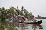 A family make use of their canoe to meander through the Alleppey backwaters in Kerala state, India.