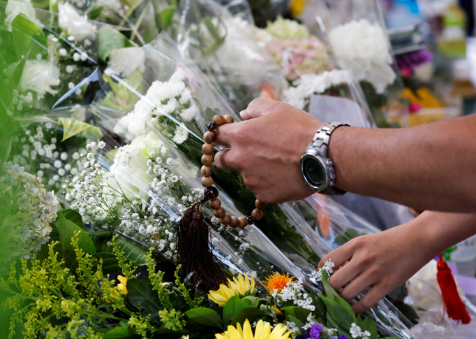 People offer flowers at the site where late former Japanese Prime Minister Shinzo Abe was shot while campaigning for a parliamentary election, near Yamato-Saidaiji station in Nara, Japan, on July 9, 2022.