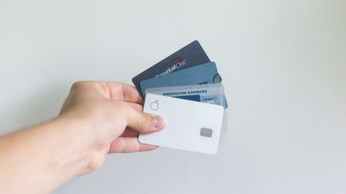 Person holding several credit cards considering consolidating their debt with a Marcus personal loan. 