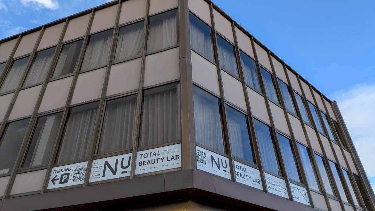 米子市西福原のNu-TOTALBEAUTYLABが入る建物外観と案内看板