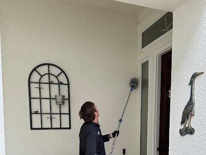 pest control tech dusting a house for spiders and hornets