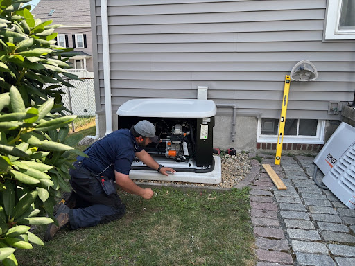 Sylvester Electric technician working on a replacement Generac standby generator in Newton Massachusetts