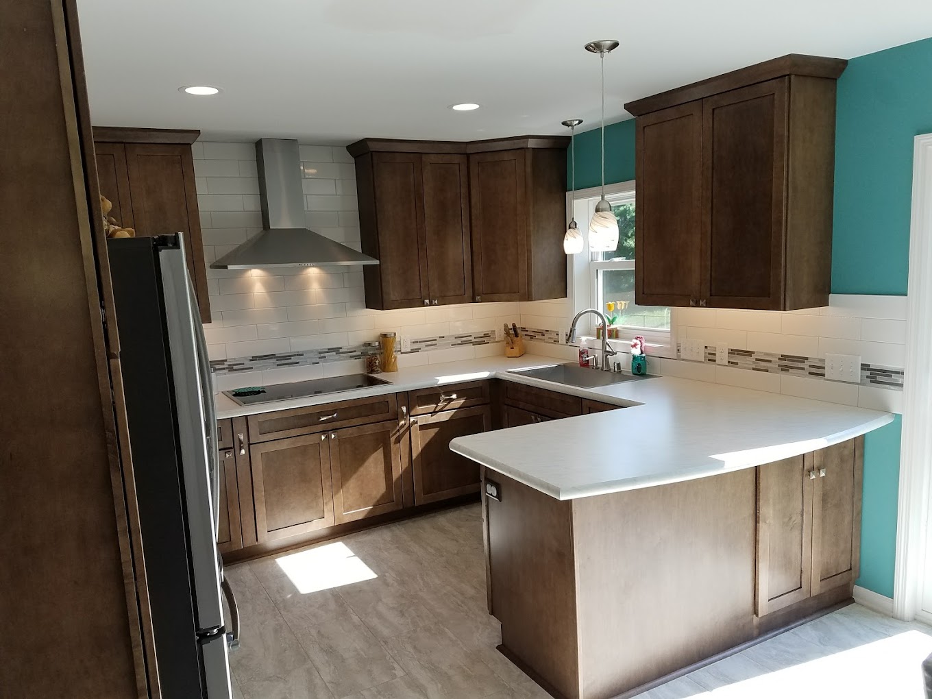 A remodeled kitchen with wood cabinets and tiled backsplash