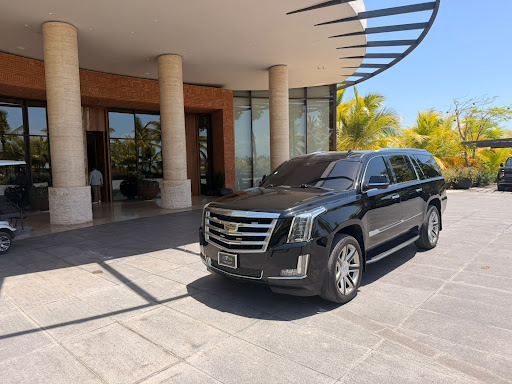 SUV Cadillac Escalade negro estacionado frente a la entrada de un hotel, en una foto de Next Ride Punta Cana
