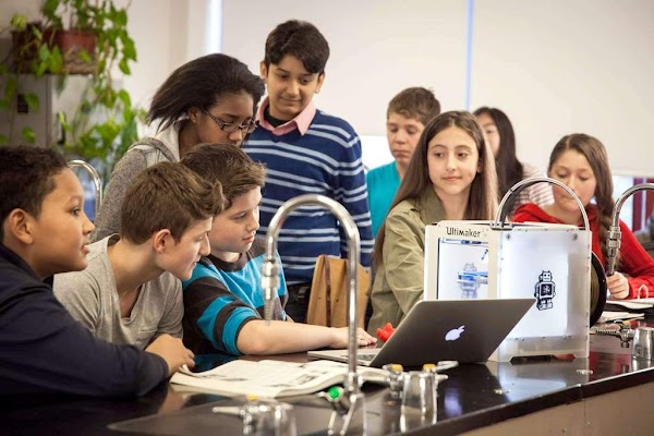 Kids gathered around lab table to review 3D printed parts