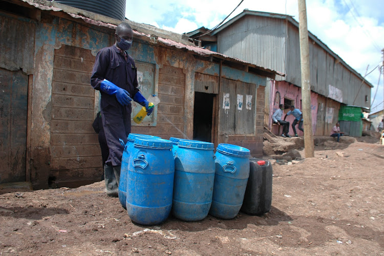 One of the operators disinfects some of the buckets used to collect the waste