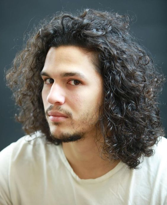 a beautiful mad with medium-length curly hairstyles for men