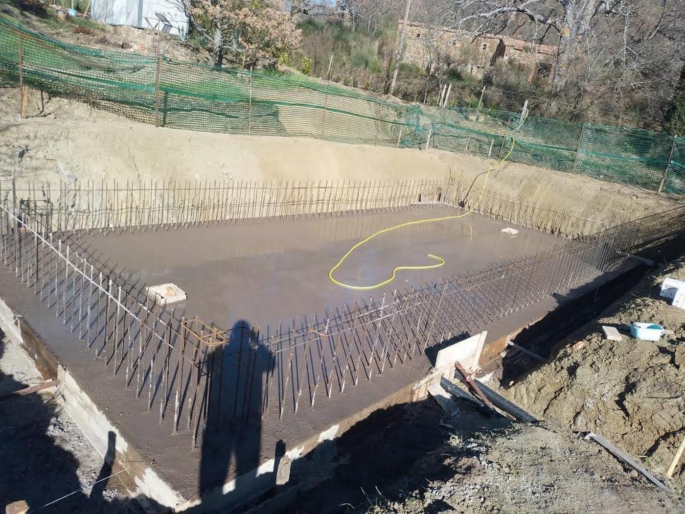 As the concrete spread and solidified, the second floor slab of the swimming pool began to take shape. The sun beat down mercilessly, casting long shadows over the pool