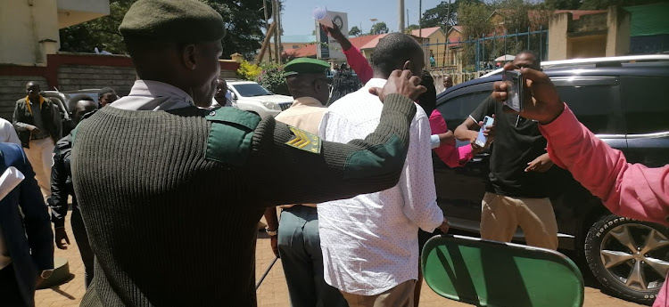 An enforcement officer escorts out of Kisii Assembly precincts a man suspected to a goon (IMAGE BY MAGATI OBEBO)