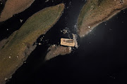 An aerial view shows a discarded sofa on the Tiete river near Ecological Tiete Park in Sao Paulo, Brazil, March 17, 2021. The Rio Tiete, which flows like a vast open sewer though Brazil's largest city Sao Paulo, is among the most polluted in the country. Over 100 km of the river are considered dead or too polluted for almost all marine life. The stinking river, which receives hundreds of tonnes of untreated sewage and waste every day, is a black mark on Brazil's wealthiest city. Picture taken with a drone. 