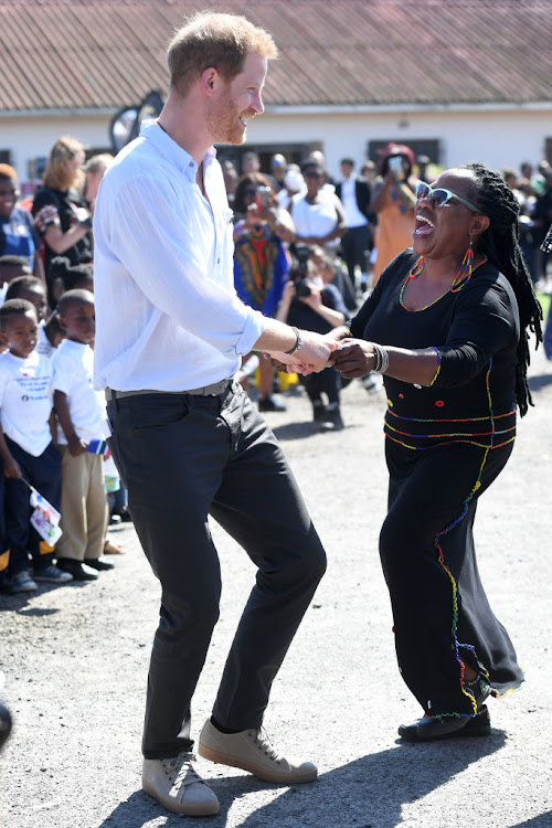 Prince Harry, Duke of Sussex, dances with a member of the Nyanga community during his tour of Southern Africa.