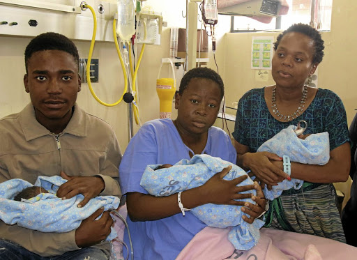 Triplets' parents Nimrod Magolo, 19, and Kholofelo Moholola, 18, share a moment with health MEC Phophi Ramathuba at the Seshego Hospital, Polokwane, yesterday. / ANTONIO MUCHAVE