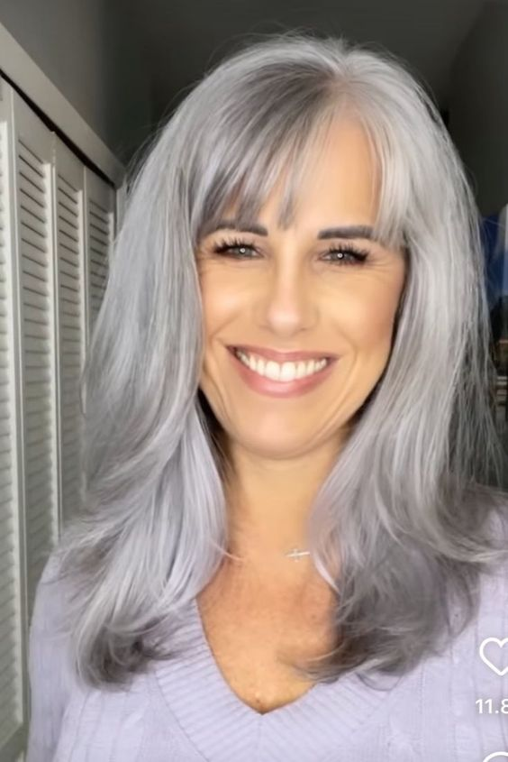 smiling lady wearing grey hairstyle with bangs