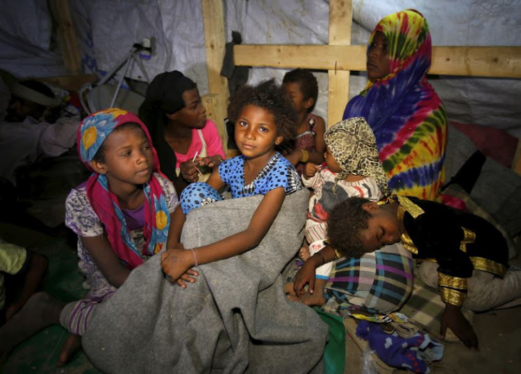 Members of a family displaced by war in the northwestern areas of Yemen sit in their makeshift hut on a street in the Red Sea port city of Hodeida, Yemen.