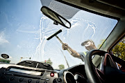 Window washers wash a motorist's windscreen at a traffic light in Pretoria on March 14, 2012.