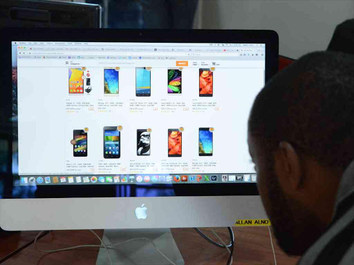 A man looks at mobile phones on the Jumia site.