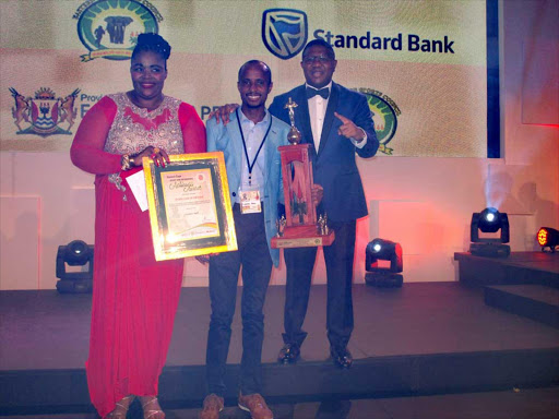 SHINING BRIGHT: Eastern Cape Arts and Culture MEC Pemmy Majodina and Sports Minister Fikile Mbalula hand star runner Lusapho April his award Picture: VUYOKAZI NKANJENI