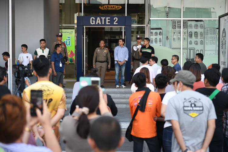 People gather outside the Terminal 21 shopping mall as they seek information on picking up vehicles and other belongings left during a mass shooting at the complex in Nakhon Ratchasima on February 9 2020.