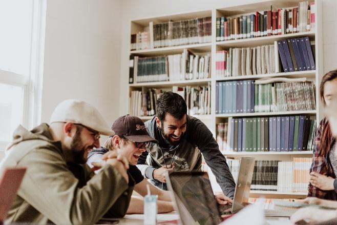 A group of people looking at a book

Description automatically generated with medium confidence