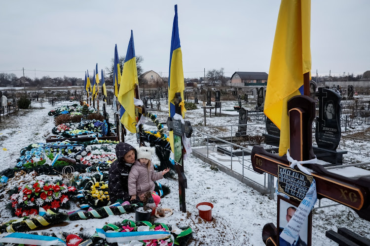 Alona Onyshchuk, 39, with her daughter Anhelina, 5, visit her husband's grave at the Alley of Heroes at a local cemetery, amid Russia's attack on Ukraine, in the village of Lozuvatka, Dnipropetrovsk region, Ukraine, January 22, 2024. REUTERS/Alina Smutko